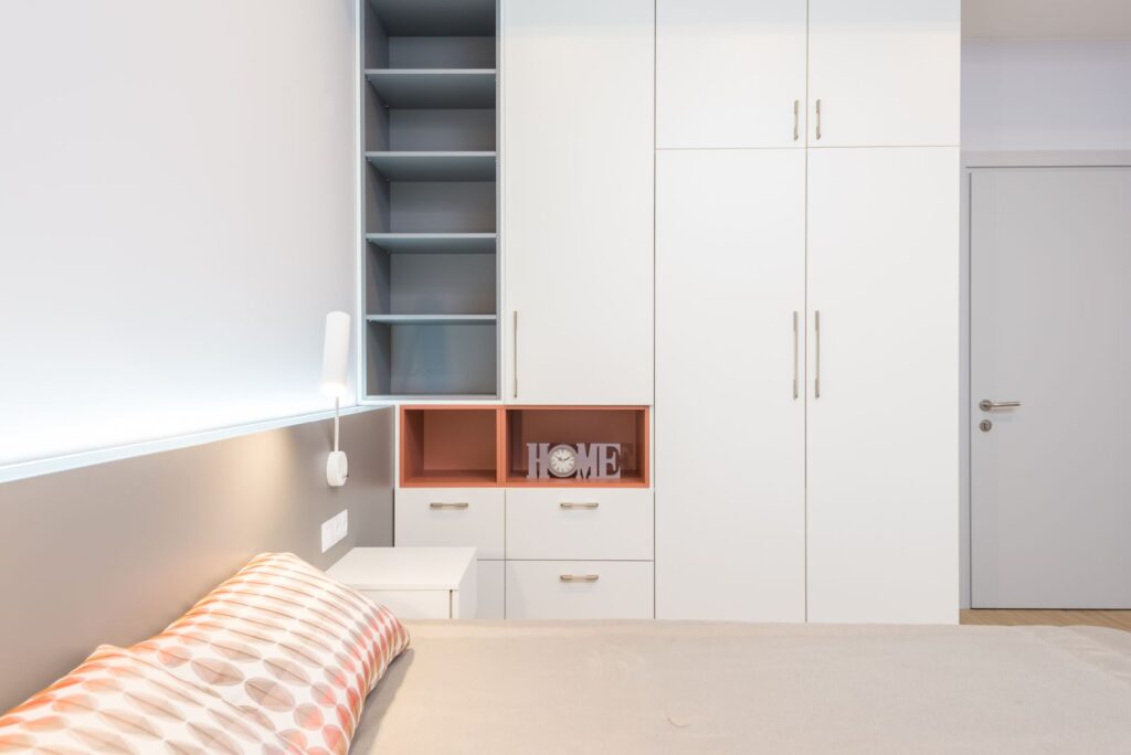 White wardrobe beside a bed in a modern Dubai apartment